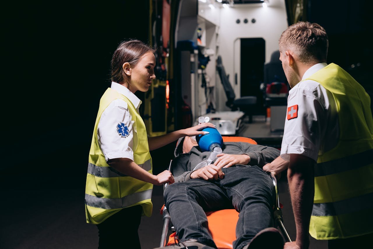 Paramedics Giving First Aid to a Person Lying on a Stretcher